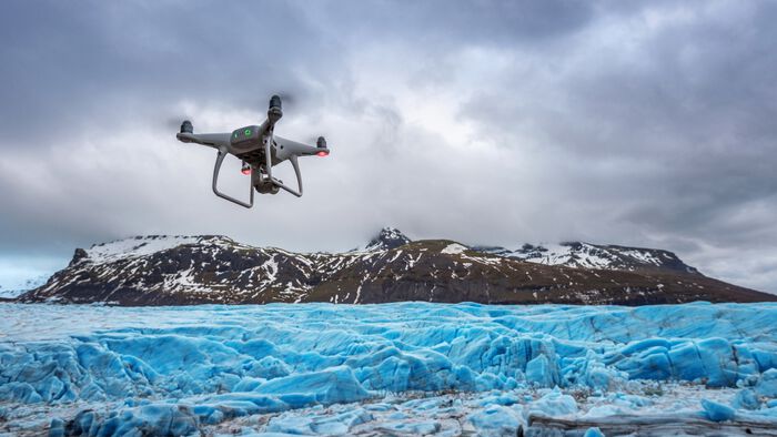 Drone med kamera flyr over et isfjell. Foto: prakobkit/Colourbox.com