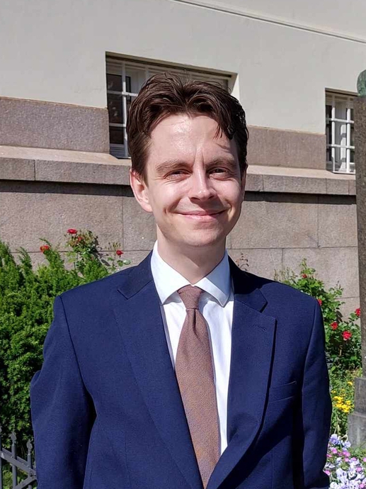 portrait photo of Johannes standing next to Fred Nobel statue