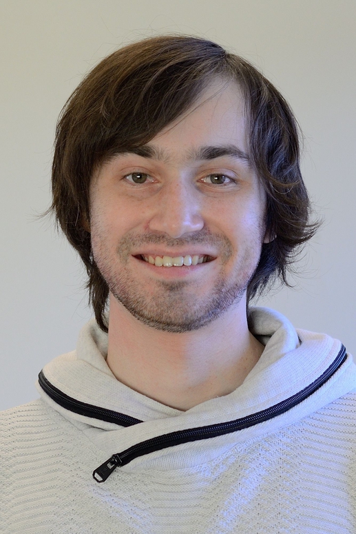 Portrait photo of a young, smiling man