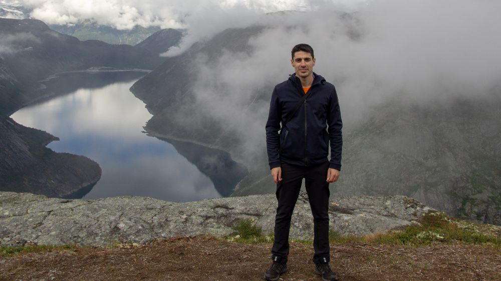photo of young man standing in front of a Norwegian mountain landscape