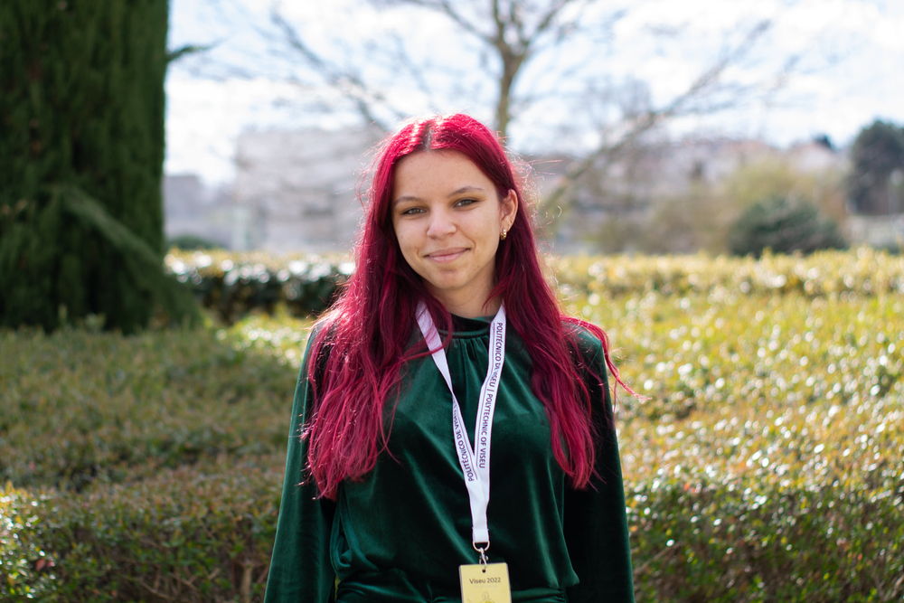 Portrait phot of a smiling young woman with pink hair 
