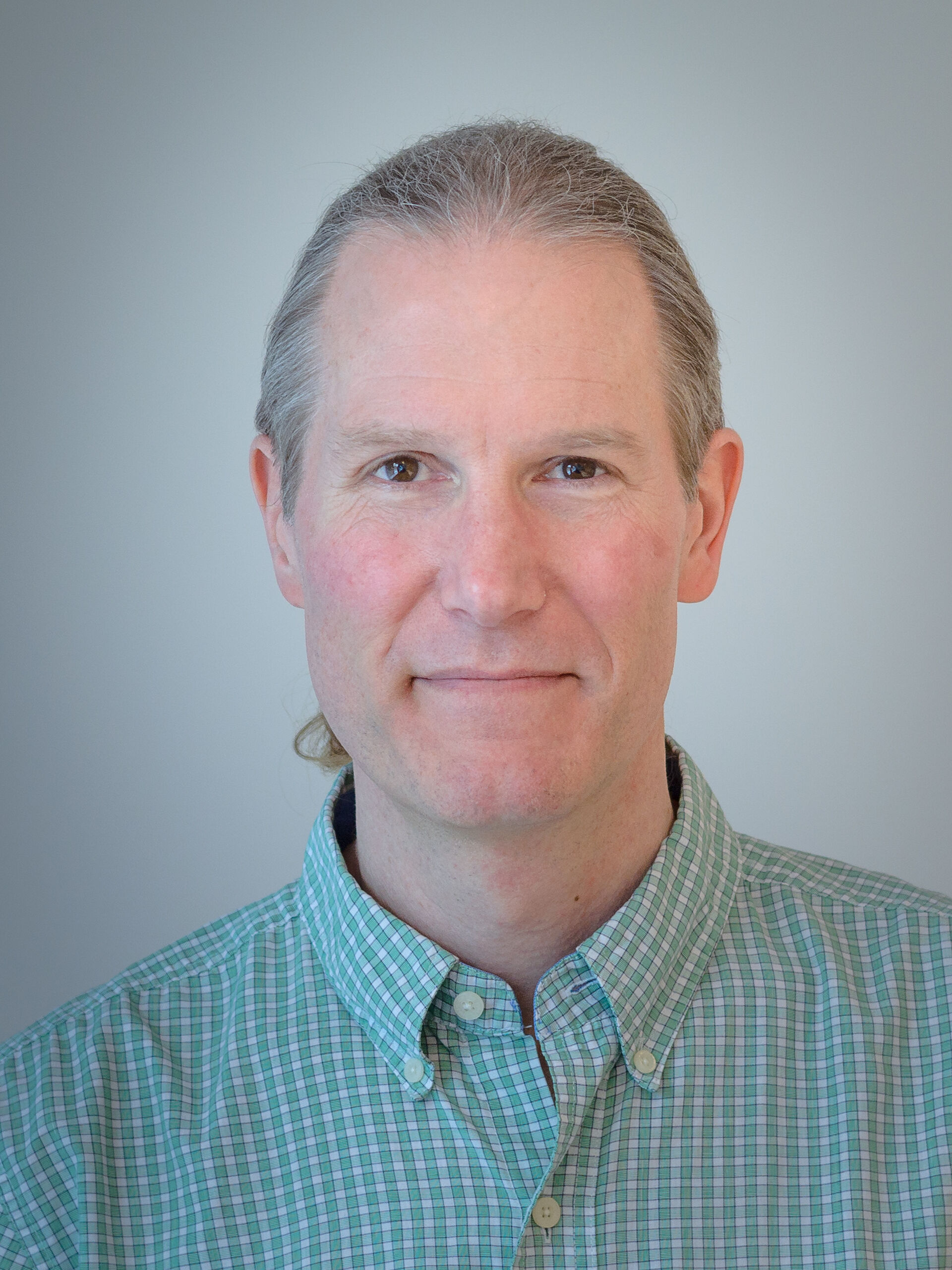 portrait photo of a man with long, grey hair