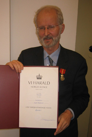 bilde av en gammel mann som holder en diplom
