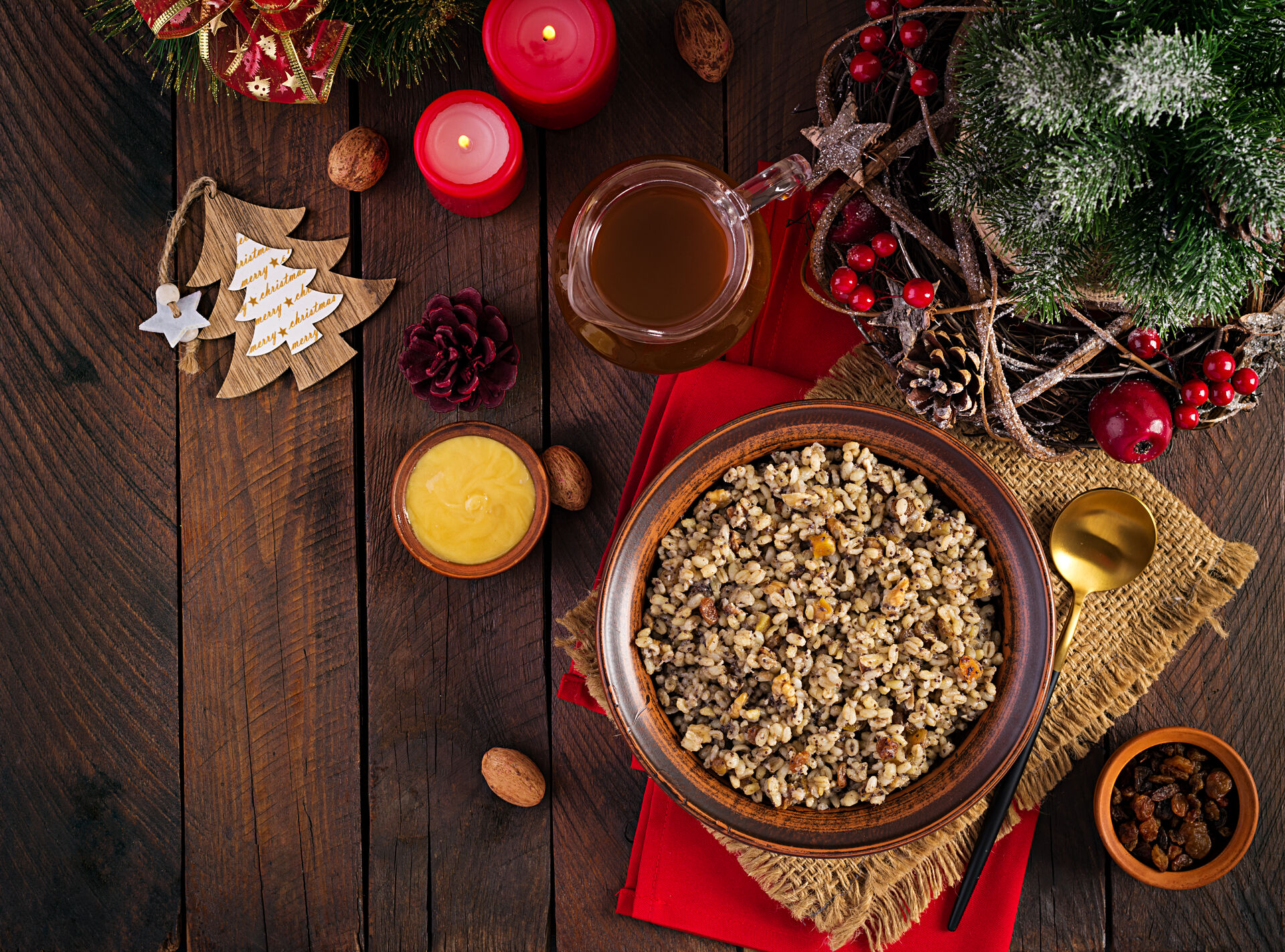 photo of a wooden table with a bowl of rice porridge, Christmas tree, candles