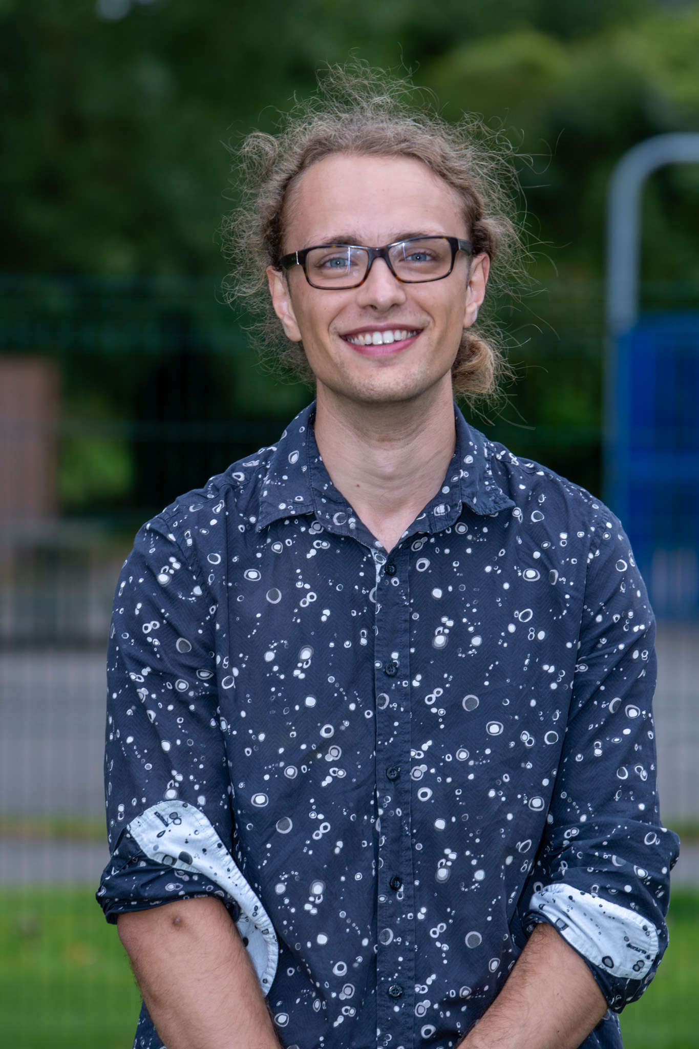 portrettbildet av en ung smilende mann med briller