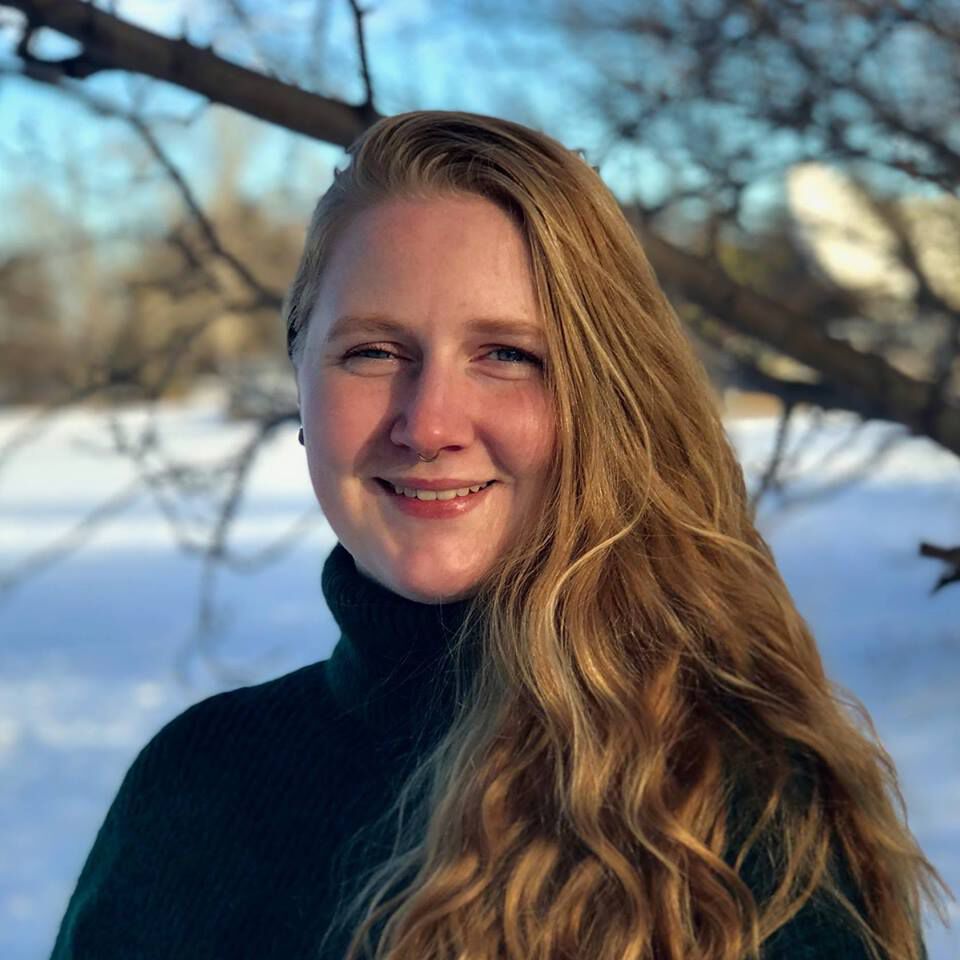 portrait photo of a young smiling woman with snow in the background