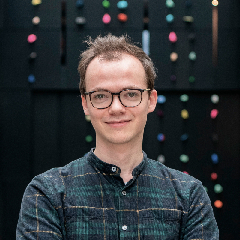 portrettbildet av en smilende ung mann med briller