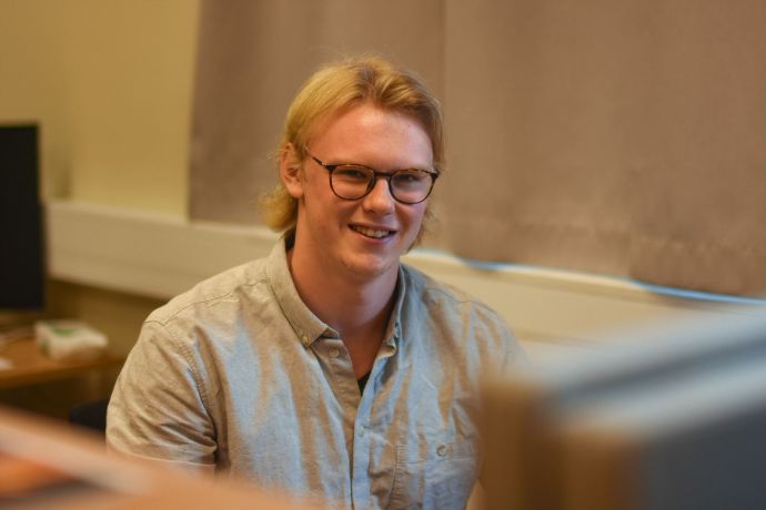 foto of en ung smilende mann med briller