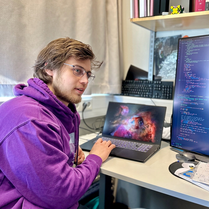 bildet av en ung man med briller og sittende foran en PC
