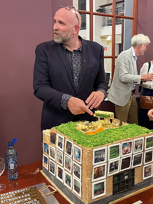 Centre chair Helge Jordal with a huge cake decorated with photos.