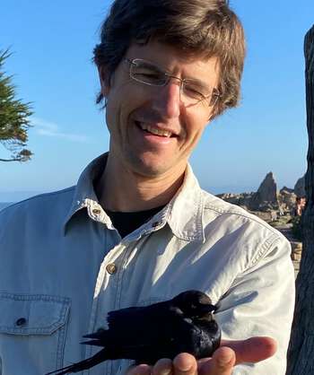 smiling man with a bird in his hand
