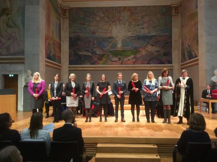 En rekke med seremonielle diplom satt opp i Universitetets aula, med Munchs malerier i bakgrunnen