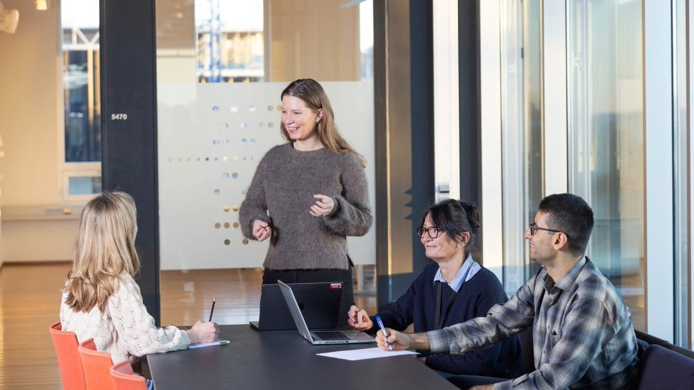 Bildet kan inneholde: hånd, skjorte, bord, møbler, bærbar datamaskin.
