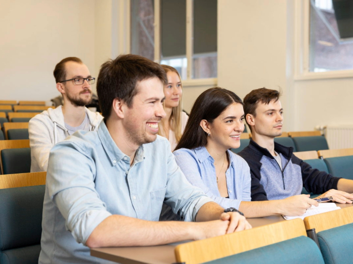Ph.d.-kandidater sitter i et auditorium og konsentrerer seg om undervisning