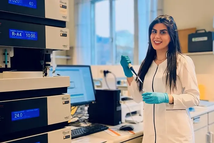 Ahtar Mahdieh i kvit frakk i laboratoriet, omgitt av tekniske instrument