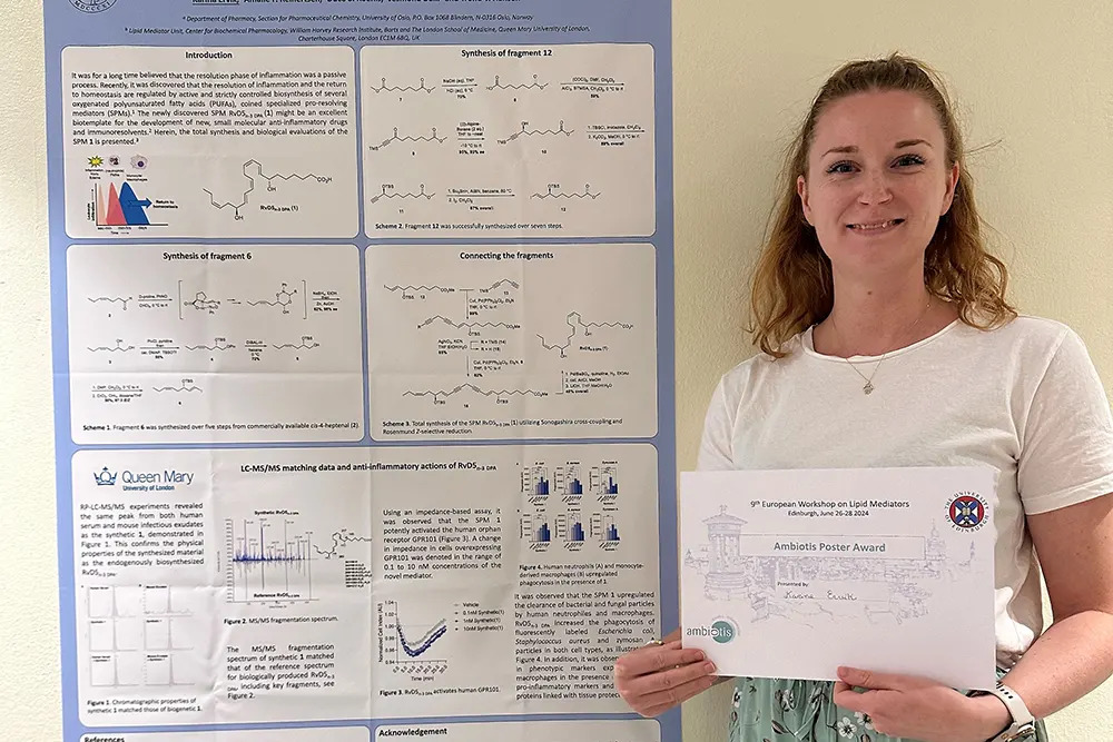 Karina Ervik ved siden av en poster. Hun holder et diplom