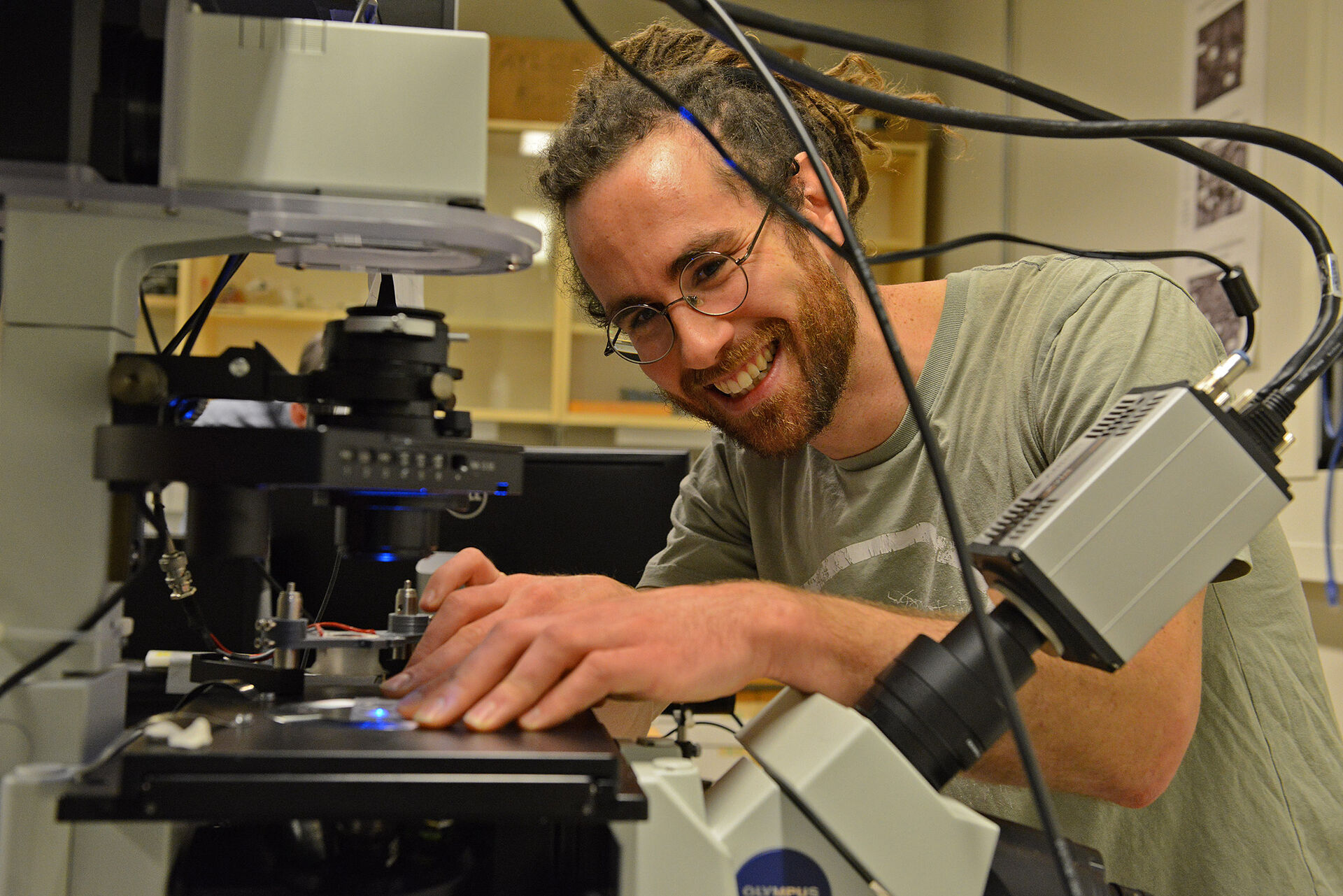 Smilende mann justerer mikroskop