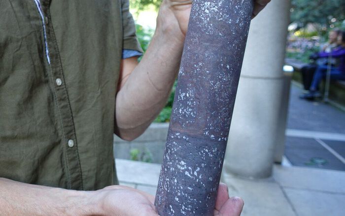 Photo: A drill core sample showing basalt from the Oslo Rift. The light spots consist of calcite—a mineral that contains bound CO2. Such samples can teach us a lot about how volcanic rocks can sequester CO2. The sample is presented by Henrik H. Svensen. Photo: Gunn Kristin Tjoflot.
