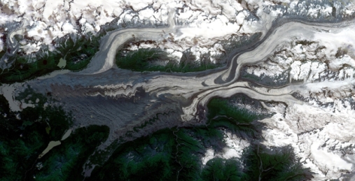 Chugach Mountains, Alaska:  RapidEye satellite false colour image of the lower part of Martin River Glacier in the Chugach Mountains, Alaska. The ripples and curved moraines are an indication of unstable, episodic or pulsating glacier flow. Copyright Planet Labs, Inc. CC-BY-SA 4.0.