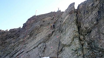 UiO scientists at work placing temperature loggers inside the mountainside containing permafrost. The picture portrays “Mannen”, one mountain that is at risk of collapsing. Photo: Department of Geosciences/UiO.