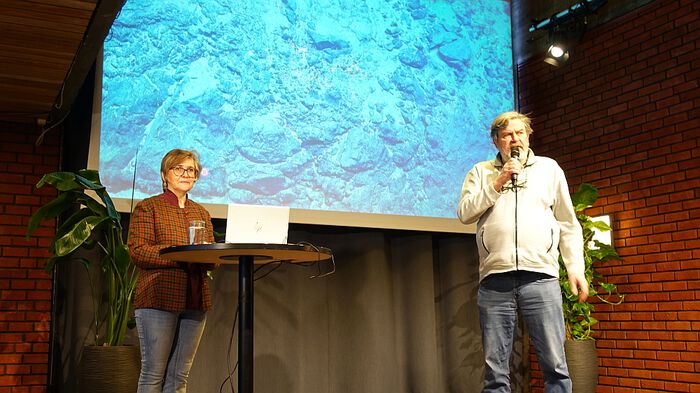 Photo: Professor Carmen Gaina on stage in the Science Library at the University of Oslo. On the right is Professor Trond Torsvik, who moderates the questions from an engaged audience. In the background is an image of a seamount in the Arctic which was explored by the GoNorth2025 marine expedition. Photo: GK Tjoflot