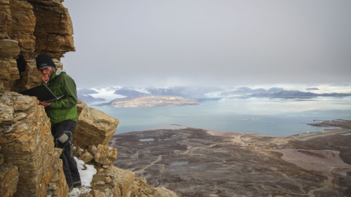 Ny-Ålesund: Permafrost finnes både i bakken og i fjellene. Her leser Jaroslav Obu, postdoktor ved Institutt for geofag av en temperaturlogger høyt oppe i en fjellside utenfor Ny-Ålesund. Temperaturmålinger er viktig data for klimaforskningen. Foto: Håvard Kristiansen