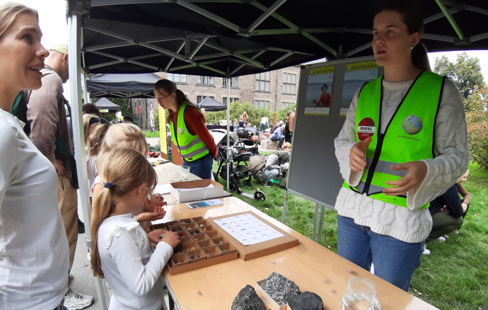 Vulkansk stein og mineraler: Flere var interesserte i stein og mineraler fra vulkaner. Her forklarer Tiril, som selv er geosstudent, litt om steinprøvene som ligger i eskene.. Foto: Gunn Kristin Tjoflot