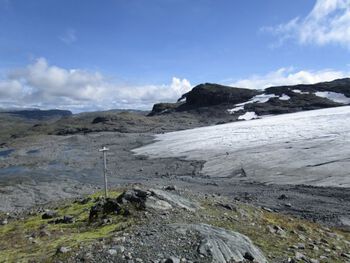 Bildet viser fronten til Midtdalsbreen sommeren 2014. I bakgrunnen sees Nordre Kongsnuten, helt til venstre bakerst i bildet skimtes Hallingskarvet som ble nasjonalpark i 2006.