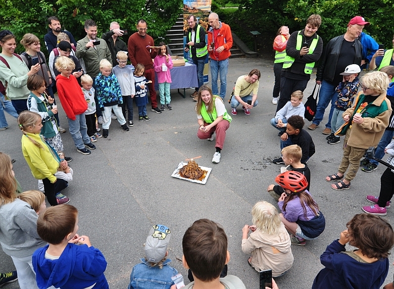 Foto: Kakevulkan: Populært blant de minste deltagerne på Geologiens dag 2023! Her viser Sara Edland Gjøsteen en eksplosjon i en kakevulkan. Eksperimentet er en sjokoladekake med innebygd colaflaske og en reaksjon mellom cola og mentos. Med mulighet å smake på kaken etterpå! Foto: Jonathan Handke og Synne Kristiansen/UiO