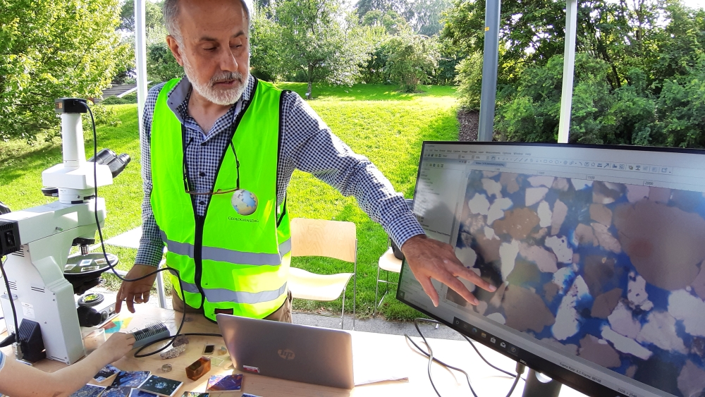 Foto: Mulighet til å se tynnslip: Salahalldin Akhavan er senioringeniør ved Tynnsliplaboratoriet ved Institutt for geofag, og forklarte de mange interesserte hva tynnslip er og hva de brukes til. Han viste flere tynnslip av mineraler og organisk materiale, og til og med et tverrsnitt av en meteoritt! Tynnslip er ikke bare fine å se på, de viser mineraler og strukturer i detalj, noe som er interessant for industrien, utbygging- og konstruksjonsarbeid, og forskning. Foto: Gunn Kristin Tjoflot/UiO
