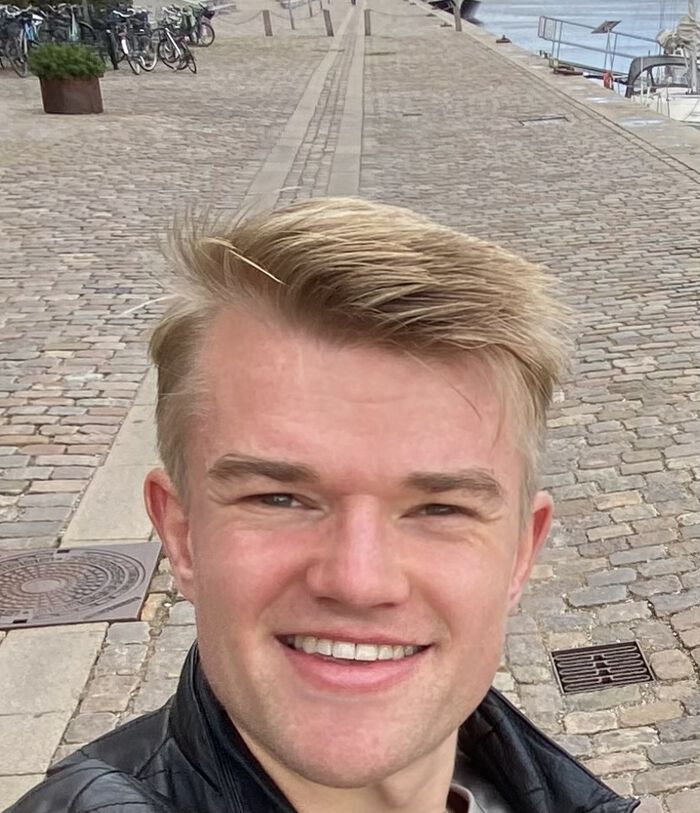 Bildet kan inneholde: hode, leppe, smil, bygning, yttertøy.