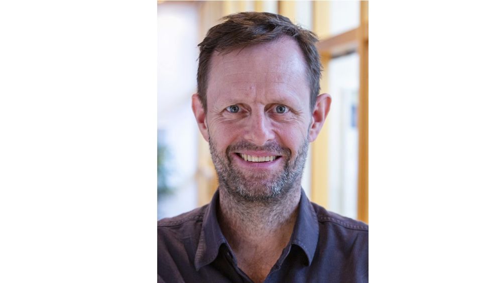 Bildet kan inneholde: person, hår, smil, skjegg, kjole skjorte.
