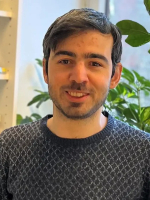 Picture of the PhD candidate wearing a blue sweater and smiling.