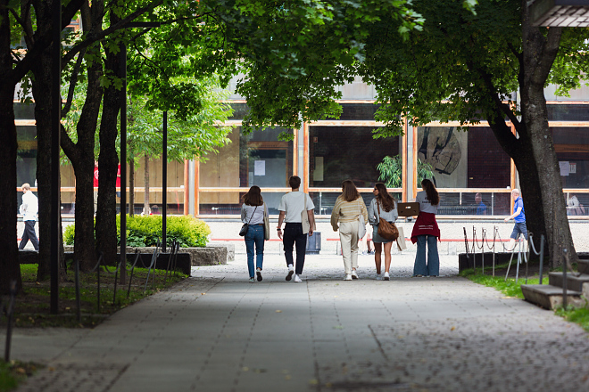 three people walking on campus