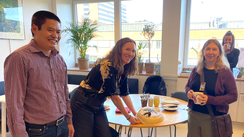 3 smilende mennesker med kake