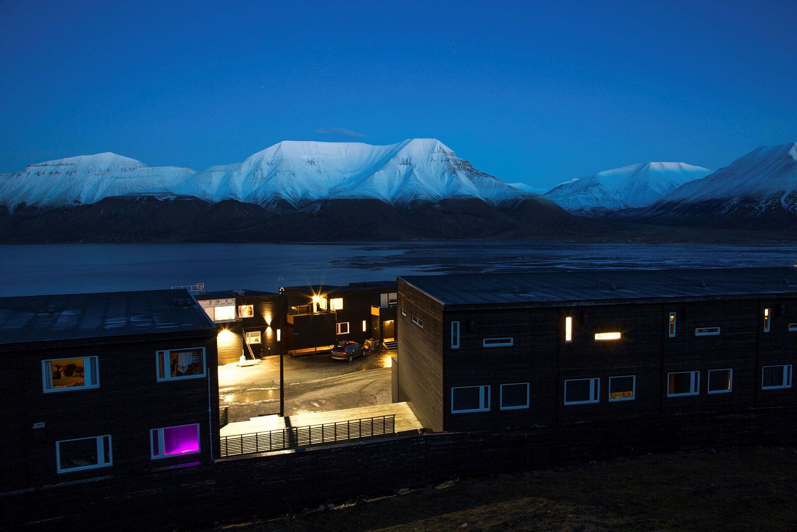Longyearbyen, Svalbard i mørketid. Fjell i blålys i bakgrunnen. 