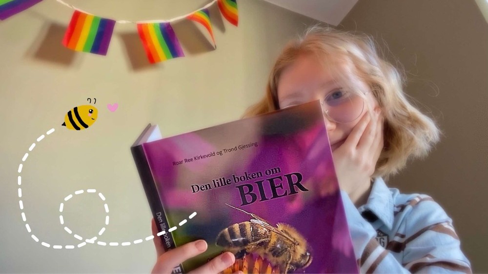 Forfatteren sitter og leser i boken "Den lille boken om bier" av Kirkevold og Gjessing. En tegnet bie "flyr ut av boken".