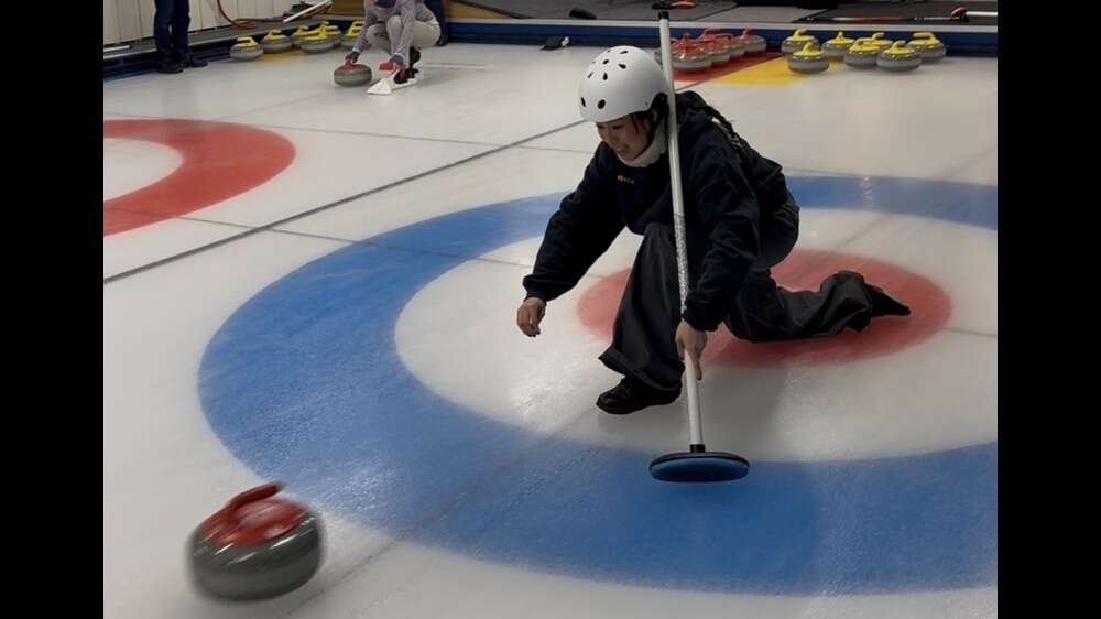 Person som sender avgårde en curlingstein.