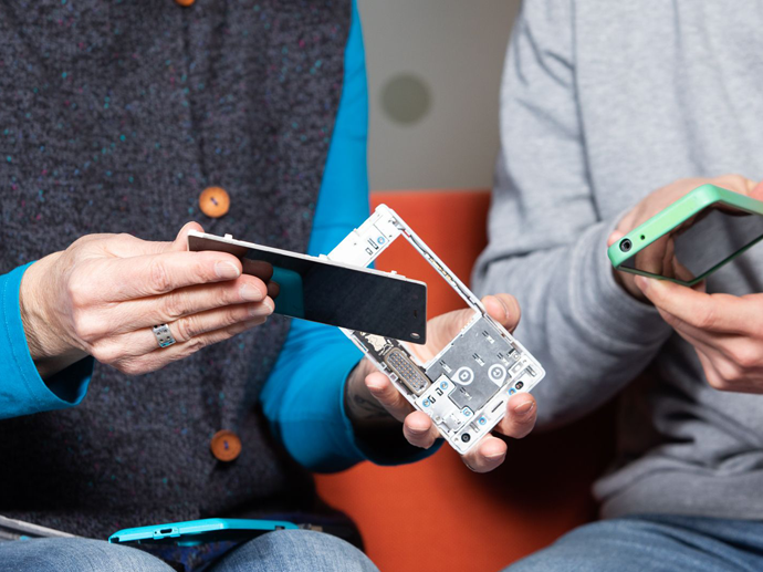 Hender som viser frem en fairphone i flere deler