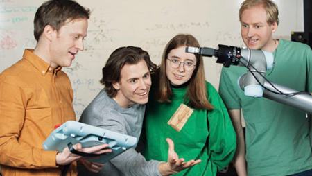 Four people and a robot arm