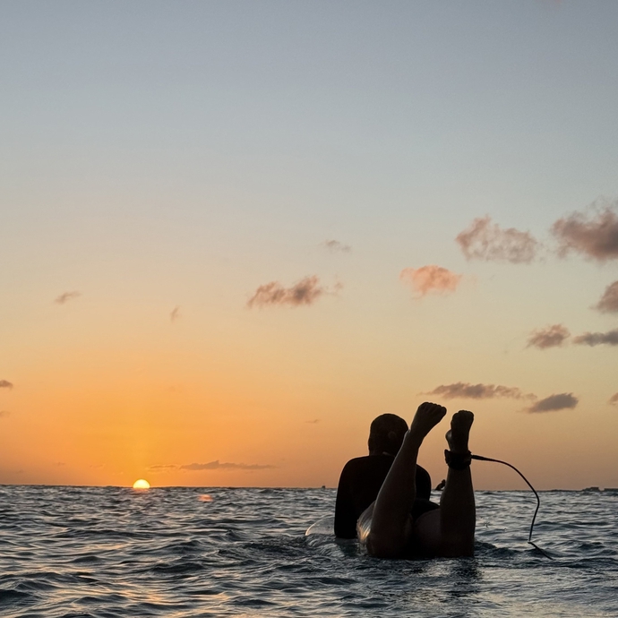 student på surfebrett i solnedgang
