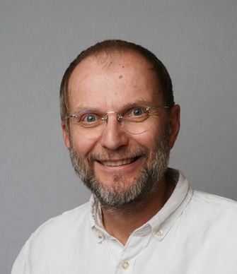 Bildet kan inneholde: panne, briller, smil, skjegg, synsomsorg.