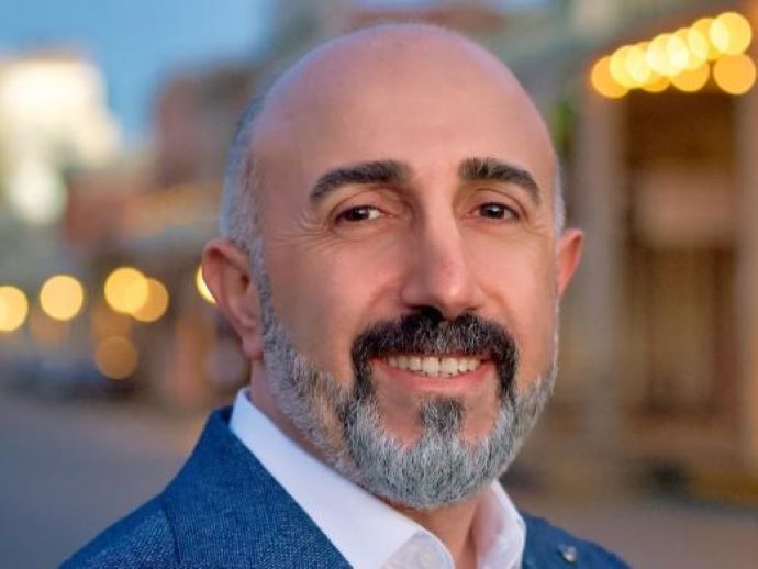 Man with a blue suit and a mustage. 