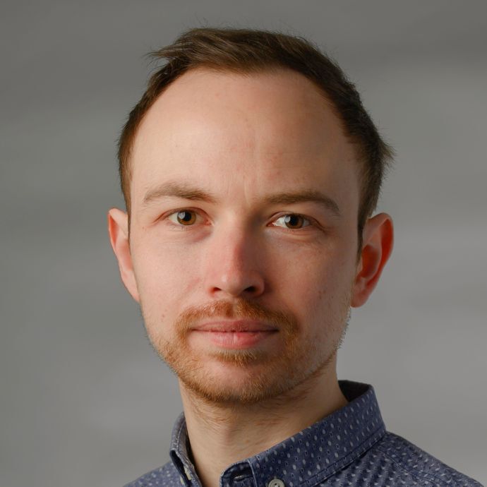 Portrait photo of Nico König. He has short hair and a dark sweater. 