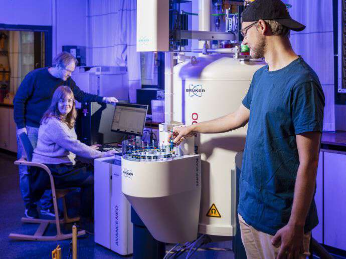 Three chemists performing research together.