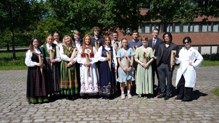 Studenter i bunader og andre pene klær utenfor Kjemibygningen. 