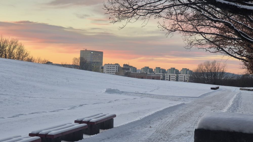 Soloppgang med snøkledte benker. 