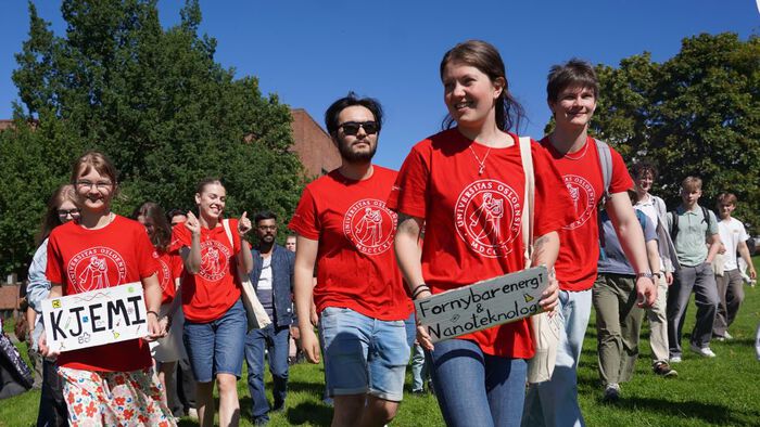 Studenter med røde t-skjorter går sammen utenfor Kjemisk institutt