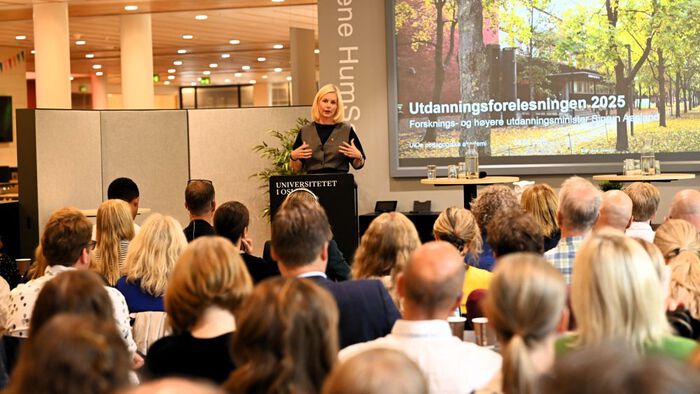 gruppe mennesker hører på kvinne som holder forelesning