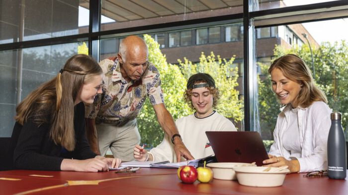 Studenter som diskuterer med foreleser